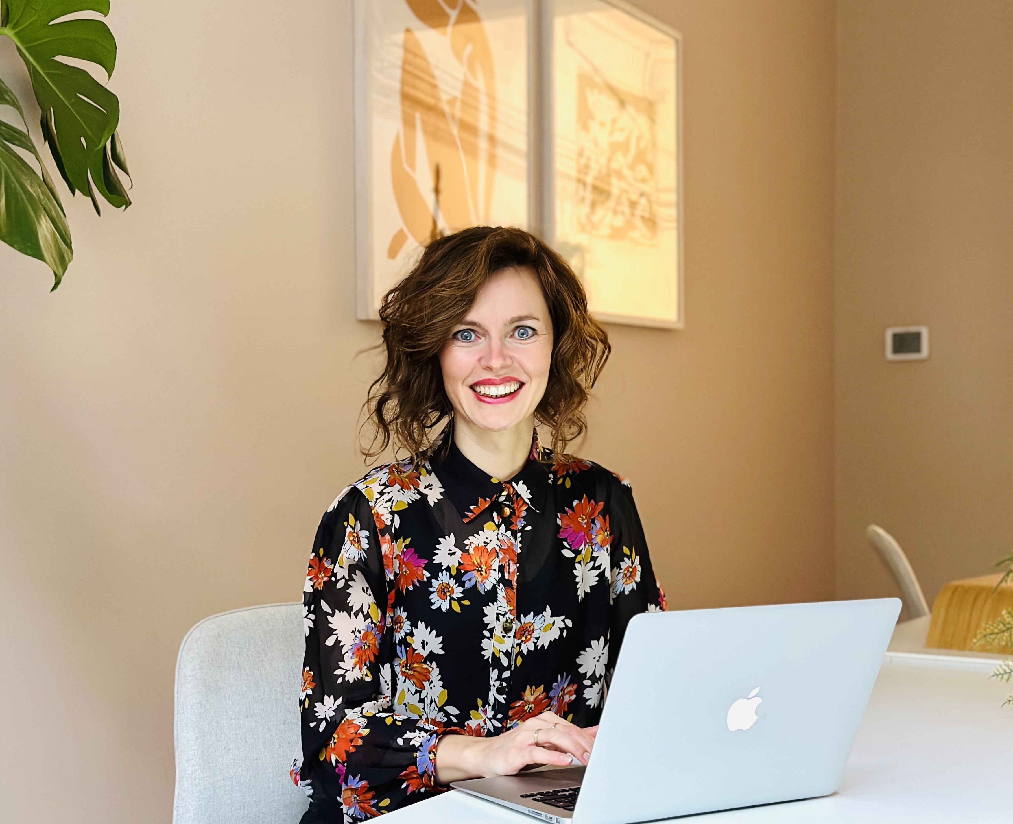 Liza Cornet smiling and working behind laptop