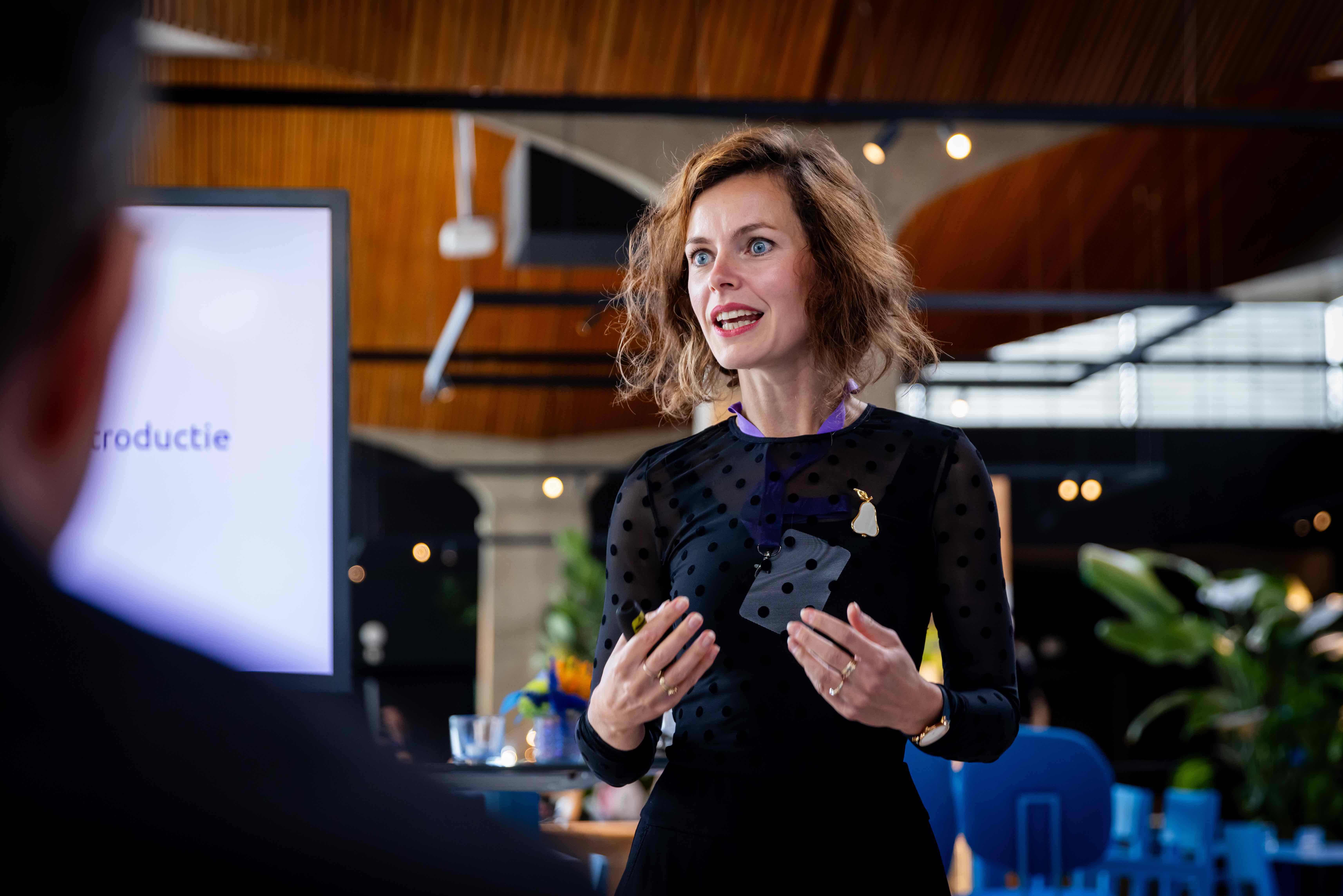 Liza staat voor een groep mensen een presentatie te geven